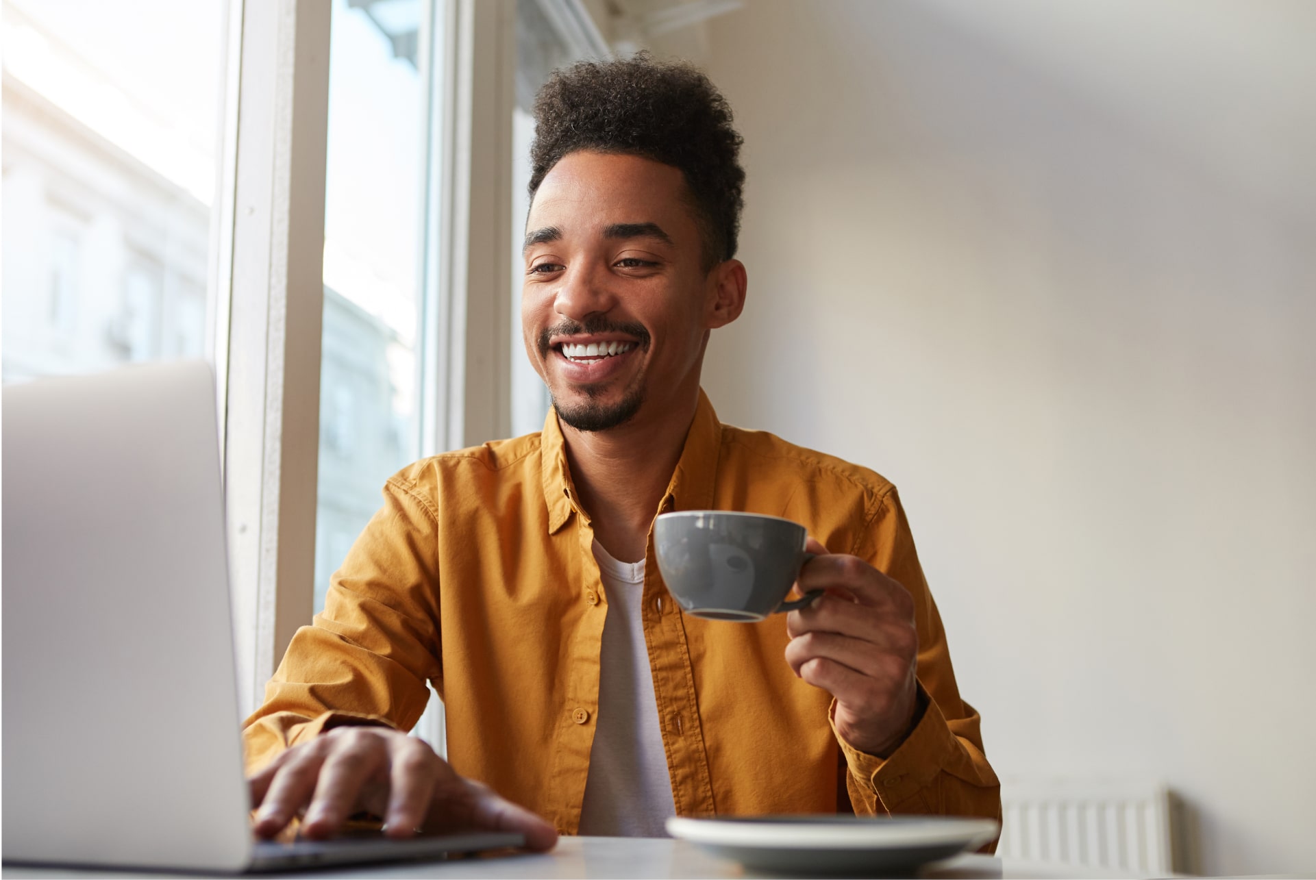 african-american-sitting-table-cafe-working-laptop-wears-yellow-shirt-drinks-aromatic-coffee-communicates-with-his-sister-which-is-far-another-country-enjoys-work 2 african-american-sitting-table-cafe-working-laptop-wears-yellow-shirt-drinks-aromatic-coffee-communicates-with-his-sister-which-is-far-another-country-enjoys-work 2